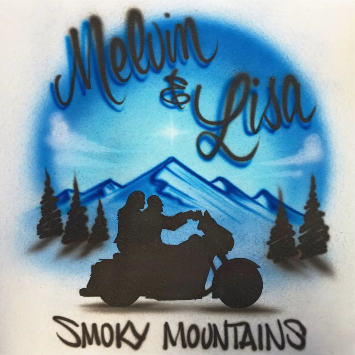 Custom airbrushed design featuring a blue mountain landscape with pine trees, a black silhouette of a couple on a motorcycle, and the text 'Melvin & Lisa' and 'Smoky Mountains'.