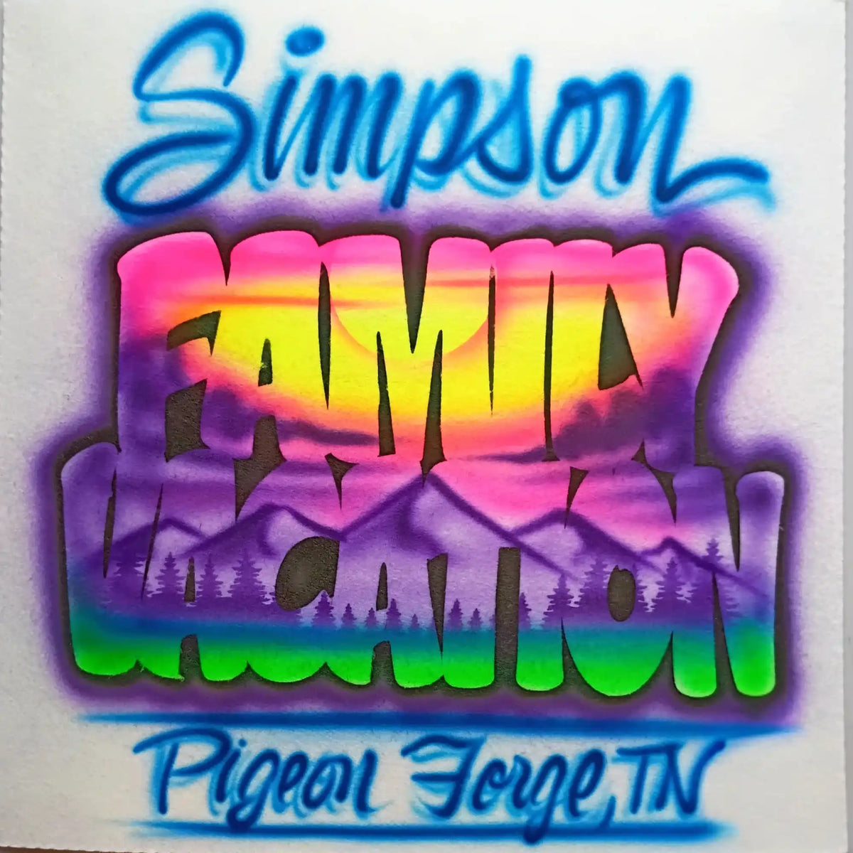 An airbrush design featuring the words 'Simpson Family Vacation' in colorful spray-paint style lettering over a mountain landscape. The top and bottom text are in blue, while the central 'FAMILY VACATION' text transitions through pink, yellow, orange, purple, and green.